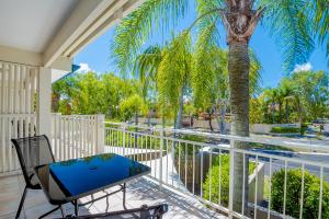 ヌーサヴィルにあるAt The Sound Noosaのヤシの木と椅子付きのバルコニー