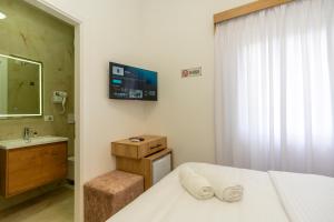 a bedroom with a bed and a sink and a mirror at Hotel Shkodra Comfort in Shkodër