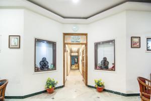 a hallway with white walls and two windows at Hotel O Lukergunj Holidays in Muthiganj