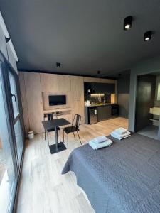 a bedroom with a bed and a table and a kitchen at Edificio Pantera - monoambiente 13 in San Martín de los Andes