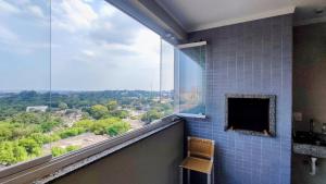 a bathroom with a large window with a view at Apartamento Vista Parque in Cascavel