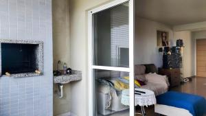 two pictures of a living room and a room with a tv at Apartamento Vista Parque in Cascavel