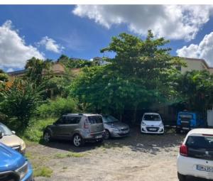 a group of cars parked in a parking lot at Studio tout confort Anse Mitan avec jardin et jacuzzi in Les Trois-Îlets