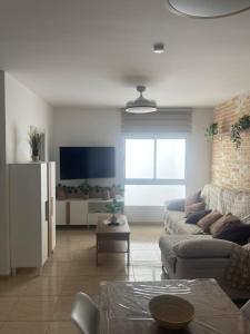 a living room with a couch and a tv at Mar y Arena in Morro del Jable