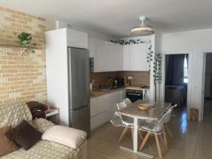 a kitchen and living room with a couch and a table at Mar y Arena in Morro del Jable +8 photos