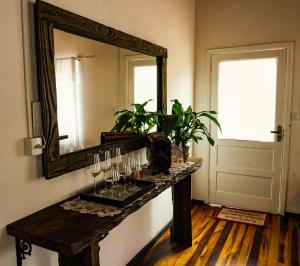 a mirror on a wall next to a table with glasses at Sítio Nono Luiz in Benedito Novo