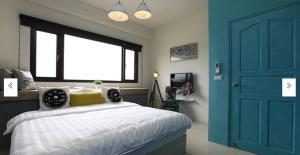 um quarto com uma cama e uma porta azul em Hi Zebra Travel B&B em Dongshan