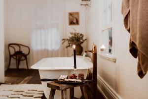 una vasca da bagno con una candela sopra di The Postman's Cottage - Hinterland Luxury a Montville