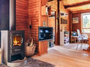 a living room with a fireplace and a tv at 6 person holiday home in Ålbæk-By Traum in Ålbæk
