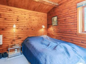 a bedroom with a blue bed in a wooden room at 6 person holiday home in Ålbæk-By Traum in Ålbæk