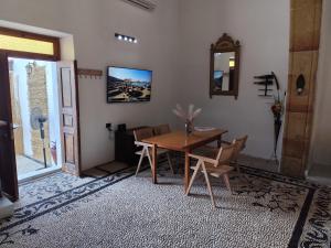 ein Esszimmer mit einem Holztisch und Stühlen in der Unterkunft Lindos Central in Lindos + 30 Fotos