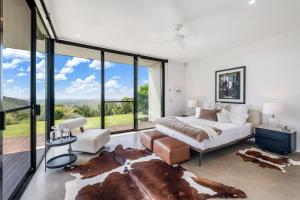 a bedroom with a bed and large glass windows at Coolum Beach Country Retreat in Yandina Creek +24 photos