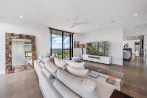 a living room with a large couch and a fireplace at Coolum Beach Country Retreat in Yandina Creek
