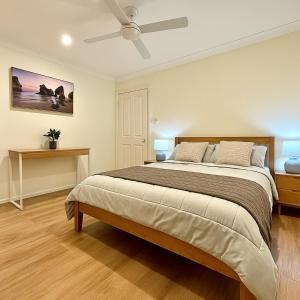 a bedroom with a large bed and a ceiling fan at Blue Horizon House with Private Pool. Pet Friendly in Nowra