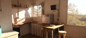 een kleine keuken met een koelkast en een raam bij La calendula eco cabaña in Los Hornillos +5 foto's