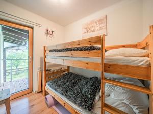sypialnia z dwoma łóżkami piętrowymi i balkonem w obiekcie Schneeflocke XL w mieście Piesendorf
