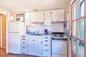 une cuisine avec des armoires blanches et un réfrigérateur blanc dans l'établissement Anchorage Cottages #1, à Long Beach 23 autres photos