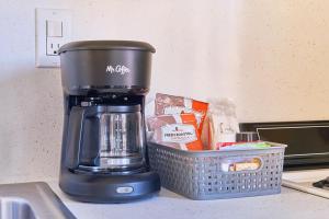 une cafetière assise sur un comptoir à côté d'un panier dans l'établissement Anchorage Cottages #1, à Long Beach