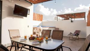 einen Tisch mit einer Obstschale auf einer Terrasse in der Unterkunft Beautiful House in Playa del Carmen in Playa del Carmen