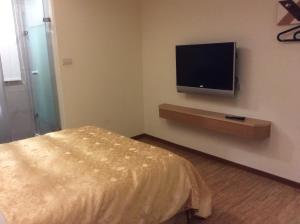a bedroom with a bed and a flat screen tv at 紫園旅社Purple Garden Hotel in Taipei
