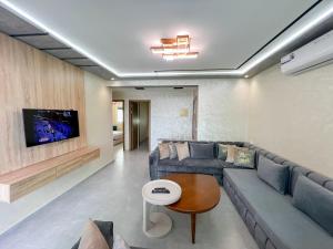 a living room with a couch and a tv at Visit Chamal - Raihana in Oued Laou