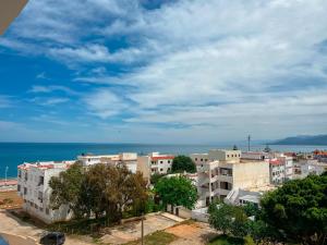 a group of buildings with the ocean in the background at Visit Chamal - Raihana in Oued Laou