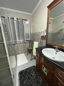 um banheiro com uma pia e um espelho em Island Haven - Cantinho da Ilha em Porto Formoso