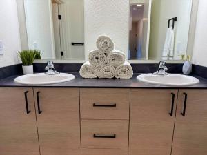 une salle de bain avec deux lavabos et un grand miroir dans l'établissement Homestead Village - Two Bedroom Condo Top Floor, à Sandpoint
