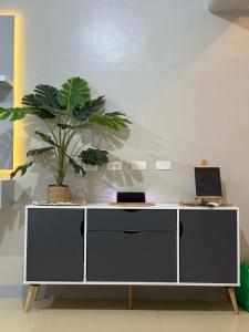 un bureau blanc avec une plante en pot au-dessus dans l'établissement Royal Ocean Crest Mactan- 5R Staycation 1110C, à Lapu Lapu City 5 autres photos