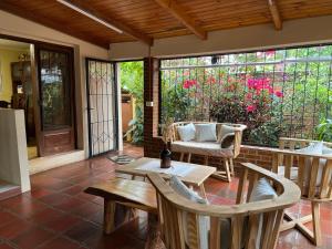 a screened in porch with a table and chairs at Tucan Hostel in Puerto Iguazú
