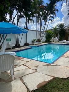 a large swimming pool with a table and umbrella at Pousada Pouso do Sô Vigario in Pirenópolis +42 photos