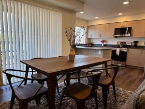 une cuisine avec une table en bois et quelques chaises dans l'établissement Homestead Village - Two Bedroom Condo Top Floor, à Sandpoint