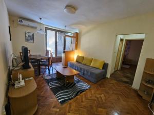 a living room with a couch and a table at Lovely square apartment Purple Velvet 43 Macedonia Stree in Skopje +15 photos