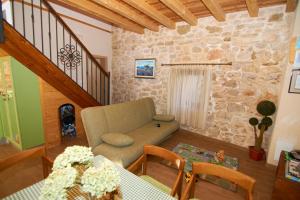 a living room with a couch and a stone wall at Seaside house for families with children Krapanj, Sibenik - 24166 in Šibenik