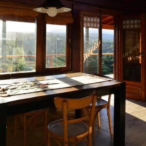 a dining room with a table and chairs and windows at Claro de Luna in Villa Yacanto