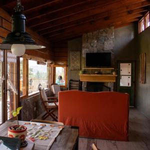a living room with a table and a television at Claro de Luna in Villa Yacanto +9 photos