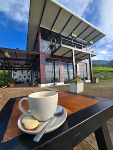 a cup of coffee sitting on a wooden table with cookies at Loft con hermosas vistas y Volcán Turrialba in Turrialba