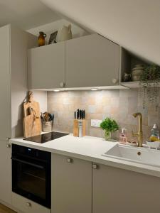 Una cocina con gabinetes blancos y un fregadero. en Meudon Jewel Near Paris, en Meudon