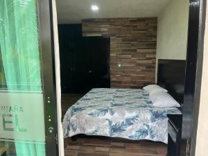 a bedroom with a bed and a brick wall at Hotel y Restaurante La Montaña in Mapastepec +1 photo