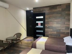 a hotel room with two beds and a table and chairs at Hotel y Restaurante La Montaña in Mapastepec