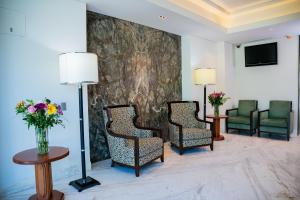 a lobby with three chairs and a tv and flowers at Vallarta Live Hotel in Puerto Vallarta