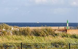 una barca sull'oceano con una barca a vela in lontananza di Ostseetraum 307 a Olpenitz Altre 19 foto