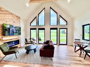 a living room with a couch and chairs and a tv at Knob Hill at Three Suns Cabins in Slade
