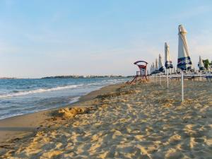 a beach with umbrellas and chairs and the ocean at ELIT Holiday Village in Obzor +24 photos