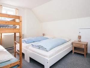 a bedroom with two bunk beds and a ladder at 4 person holiday home in Grenaa in Grenå