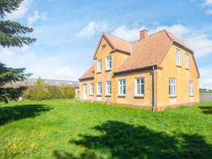 a large brick house on a green lawn at 4 person holiday home in Grenaa in Grenå