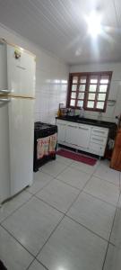 Franco da RochaにあるChácara Mato Dentroのタイルフロアのキッチン(冷蔵庫付)