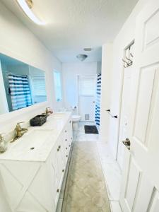a white bathroom with a sink and a shower at 3 Bedroom House with pool, 10 min from the beach in Largo