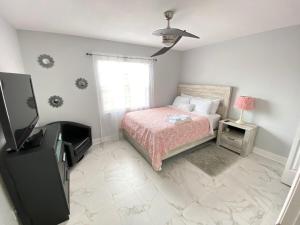a bedroom with a bed and a television in it at 3 Bedroom House with pool, 10 min from the beach in Largo +17 photos