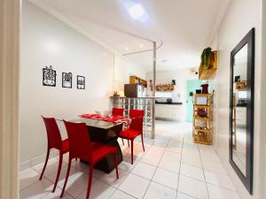 una cucina e una sala da pranzo con tavolo e sedie rosse di Estação 249 Caruaru (Casa de temporada) a Caruaru